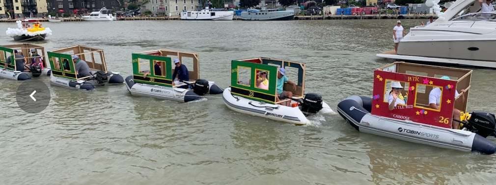 The floating train of dinghies making its way down the creek