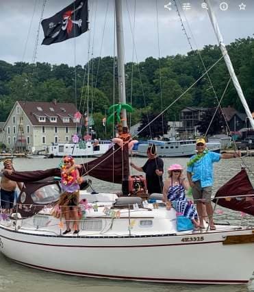 A sailboat dressed for the parade with a pirate flag