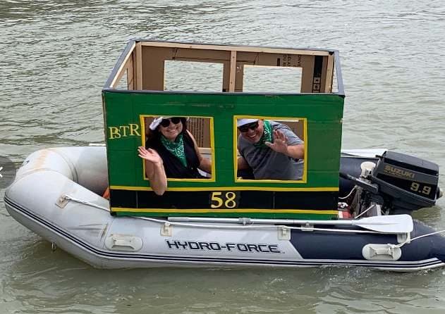 A dinghy dressed as a rail car, with members aboard