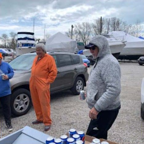 Members in work clothes chatting in the parking lot among shrink-wrapped boats