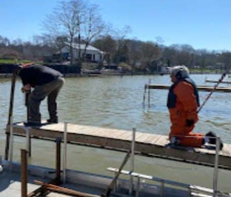 Crew members in float coats setting a dock section