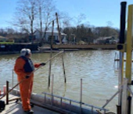 A crew member guiding a dock section into place
