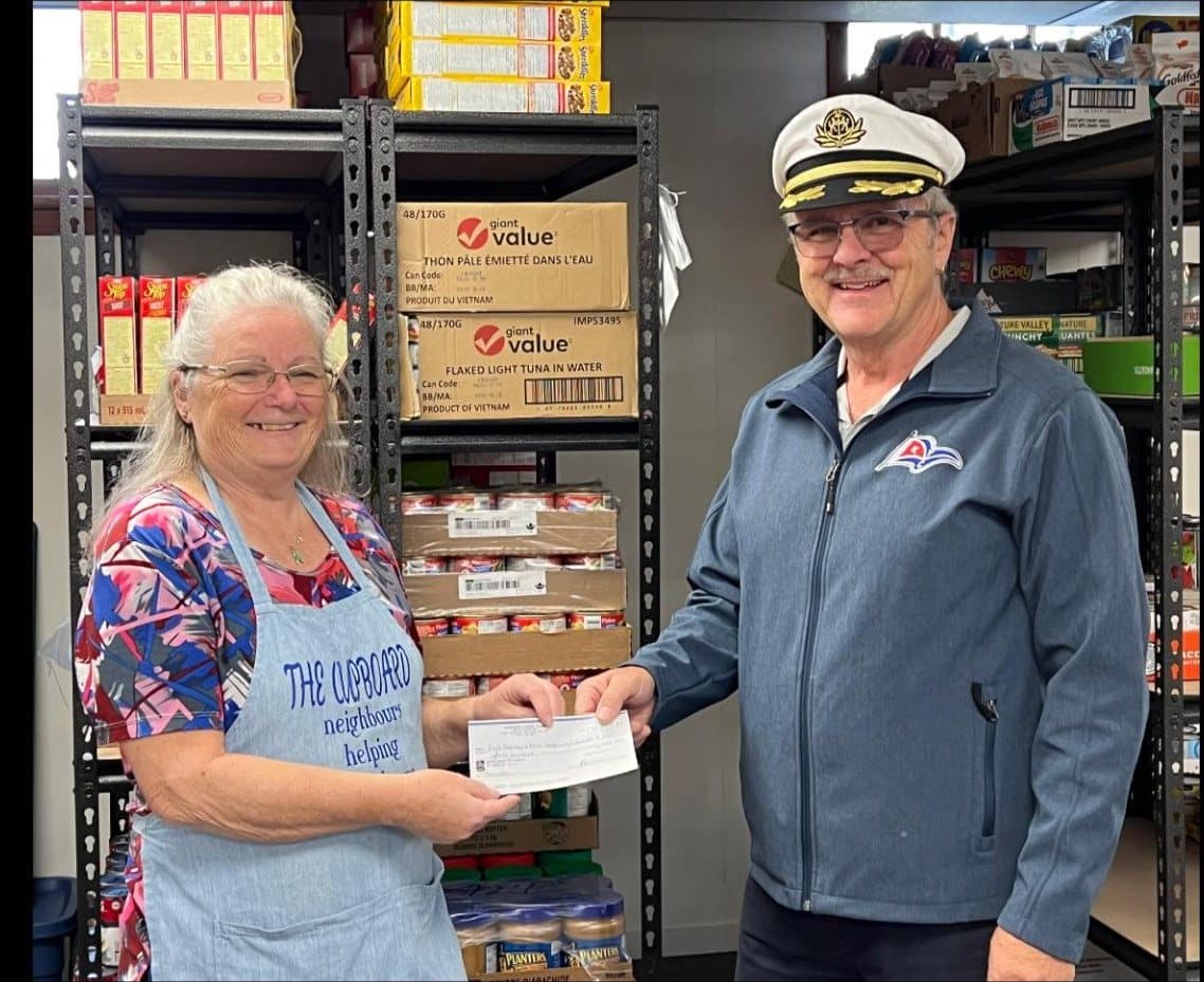 Commodore Rick Banman handing a cheque to a Port Stanley food bank volunteer