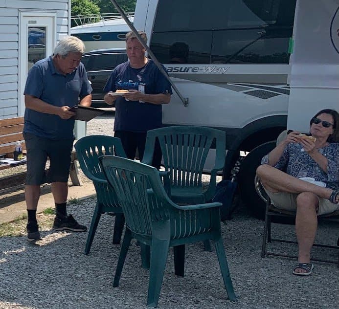 Members chatting at the picnic tables by the clubhouse