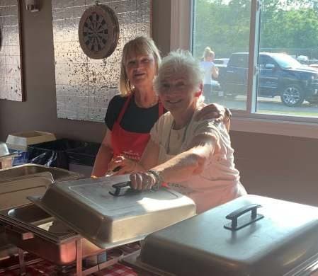Two members at the serving table