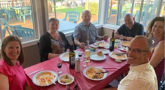 A long table of members at dinner
