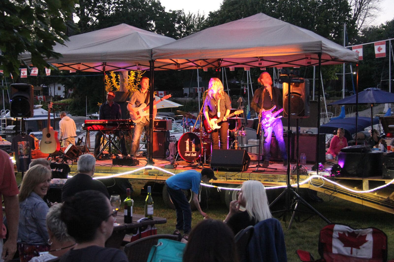 A band playing under tents on a summer night