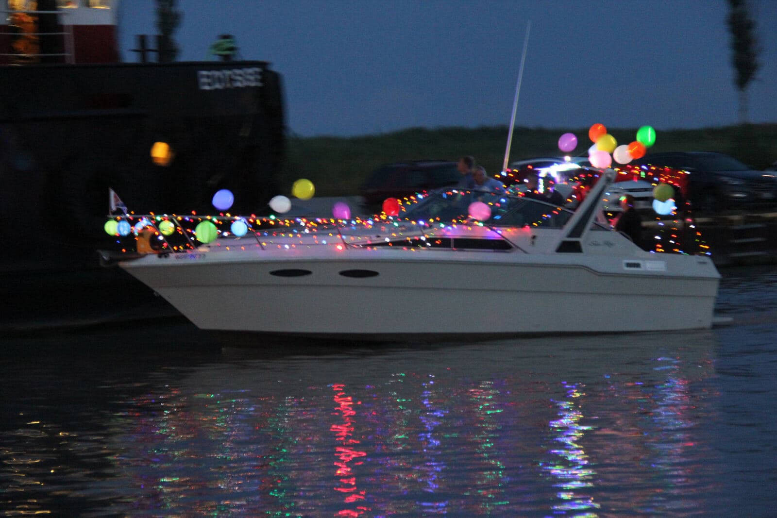 A cruiser strung with lights for the evening boat parade