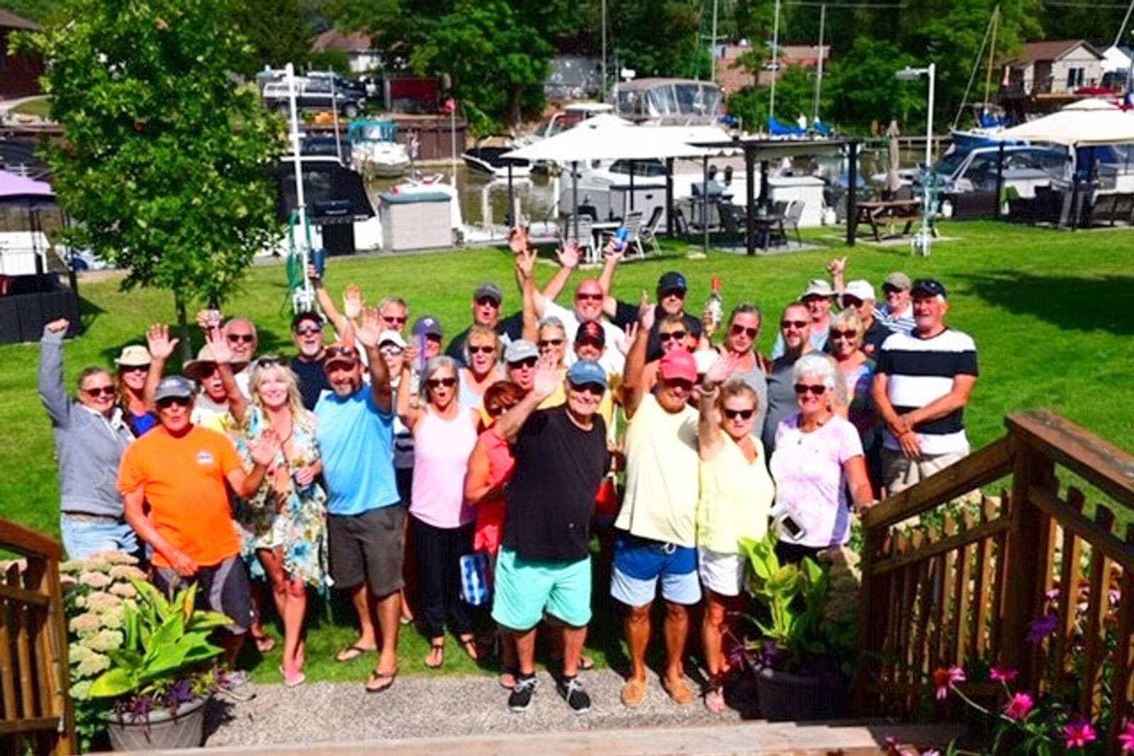 A crowd of members waving at the camera on the clubhouse lawn